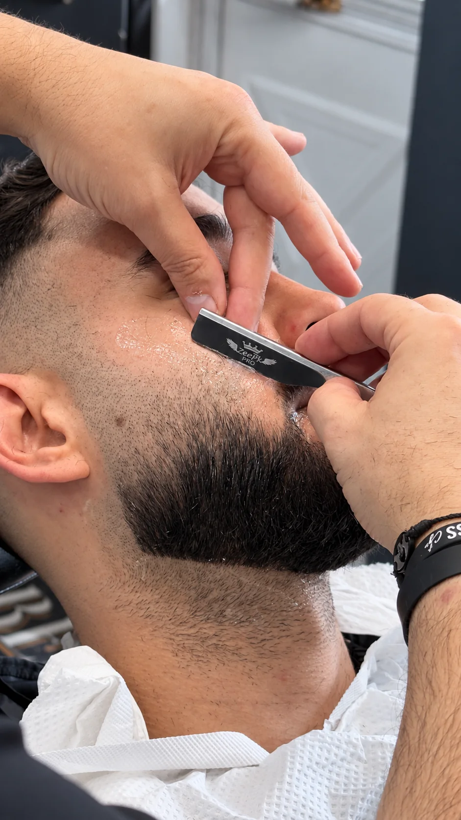 Close view of straight-razor detailing along a beard
