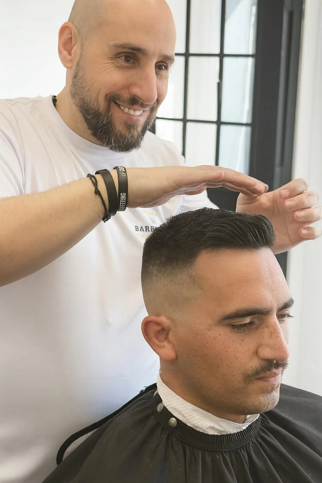Barber shaping the top of a customer’s short haircut at JR Barbershop