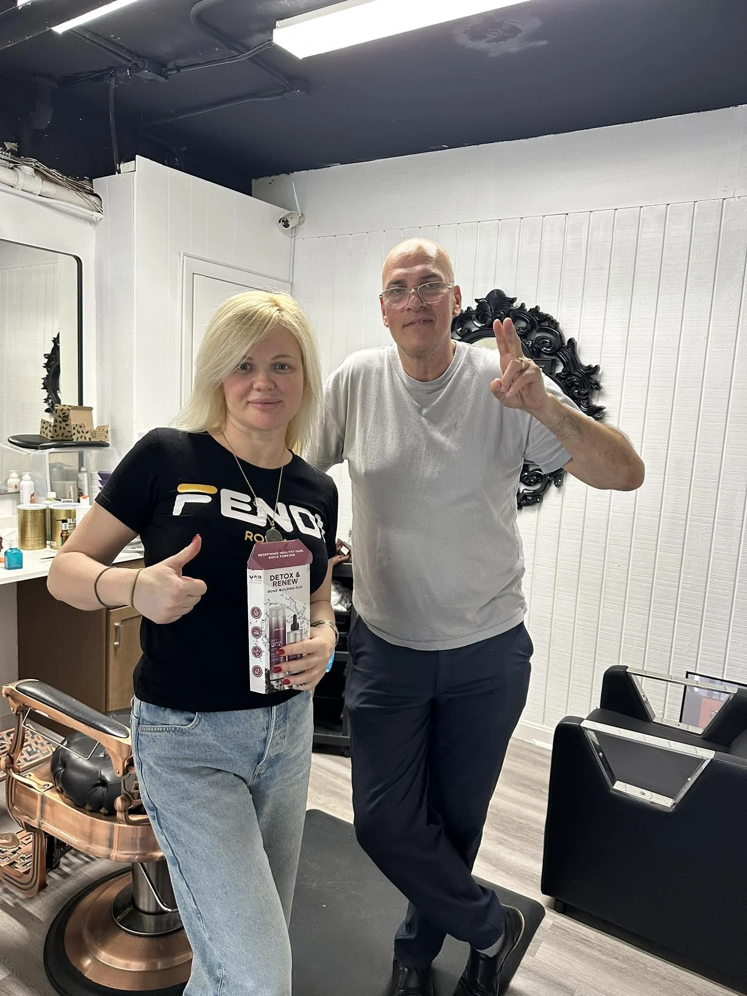 Two visitors posing together inside JR Barbershop