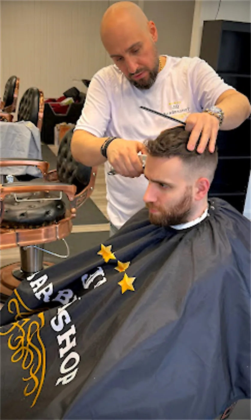 JR Barbershop barber cutting a customer's hair