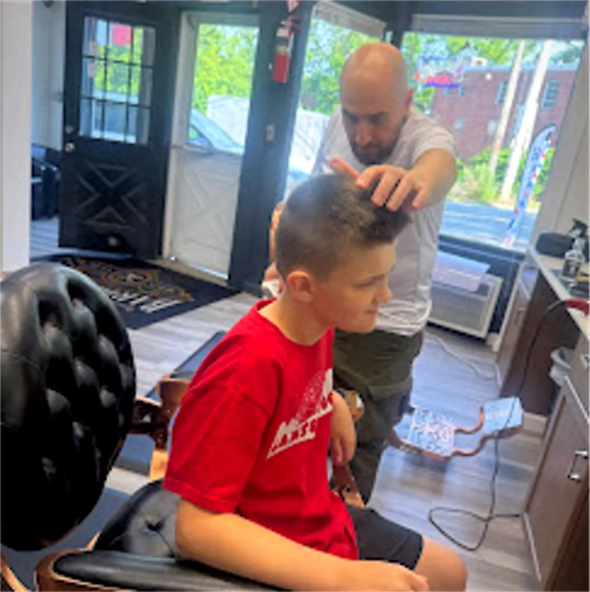 Young customer getting a haircut at JR Barbershop