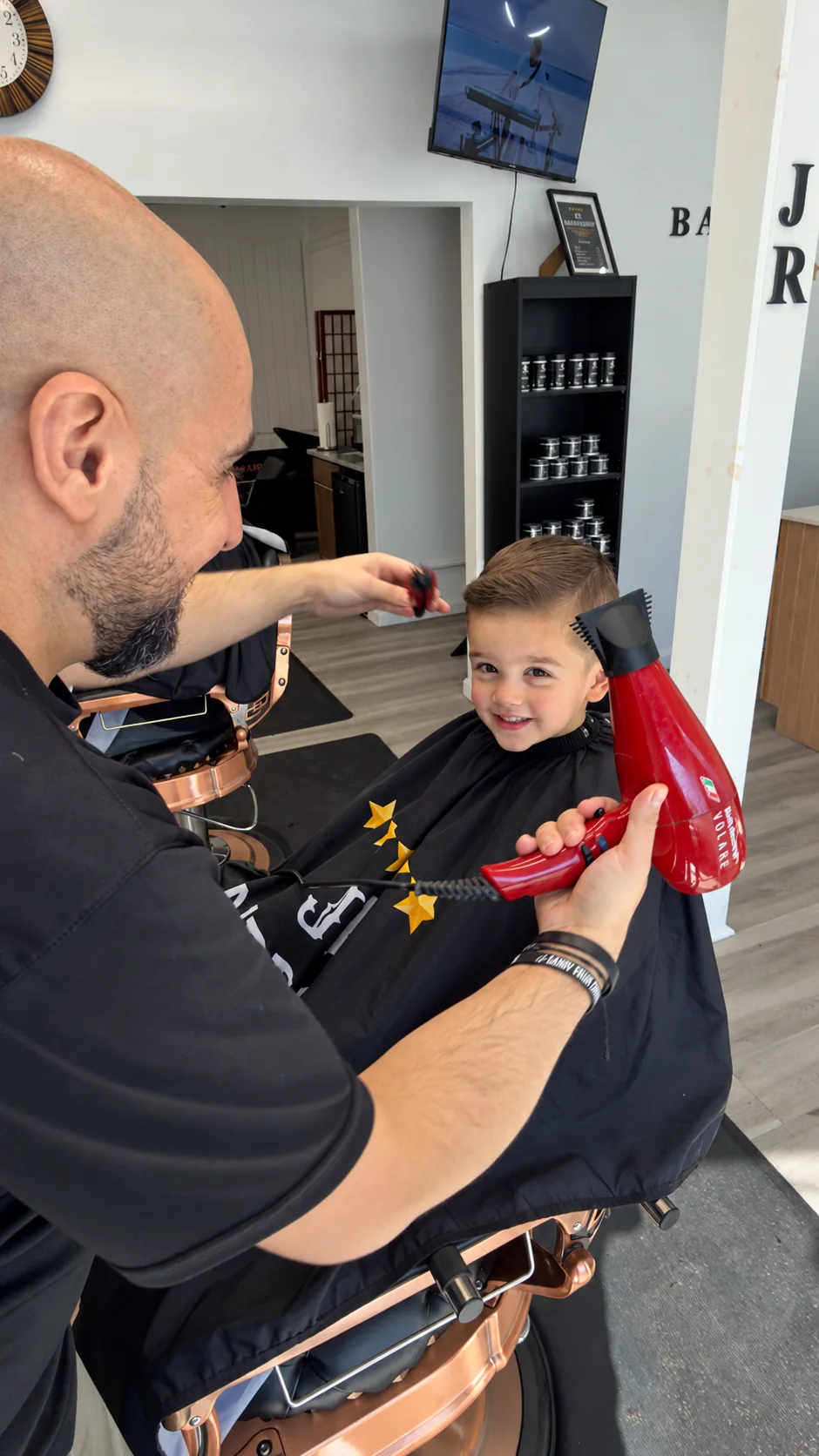 Barber blow-drying a child's hair at JR Barbershop