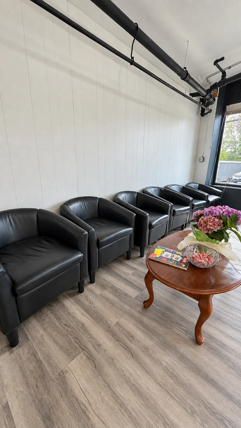 Waiting chairs and a small table inside JR Barbershop